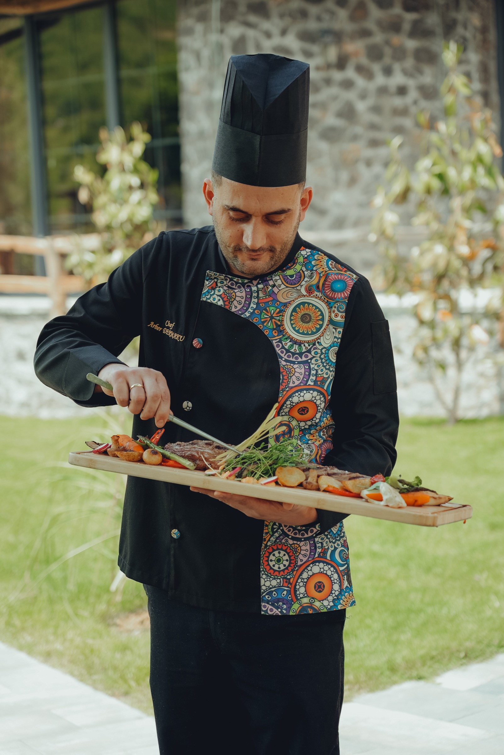 Shefi duke servirur një pjatë në Planet Resort